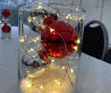 Vase med julepynt og lyskæde